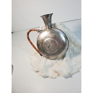 Cello Shaped Silver Vessel with a brown and caramel color curved handle